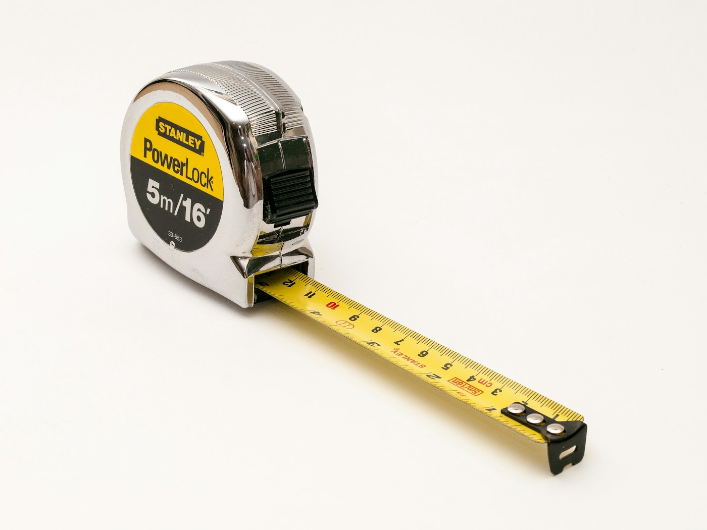 Gelbes Maßband auf weißem Hintergrund; Symbolfoto, keine Vermessung einer NGI-Wohnung