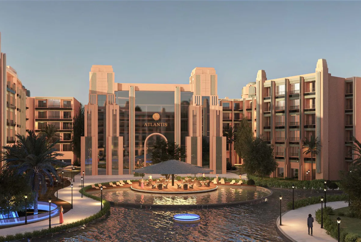 atlantis — developer visualisation — Modern luxury resort entrance with pinkish buildings, a water feature, palm trees, and outdoor seating under a large umbrella.
