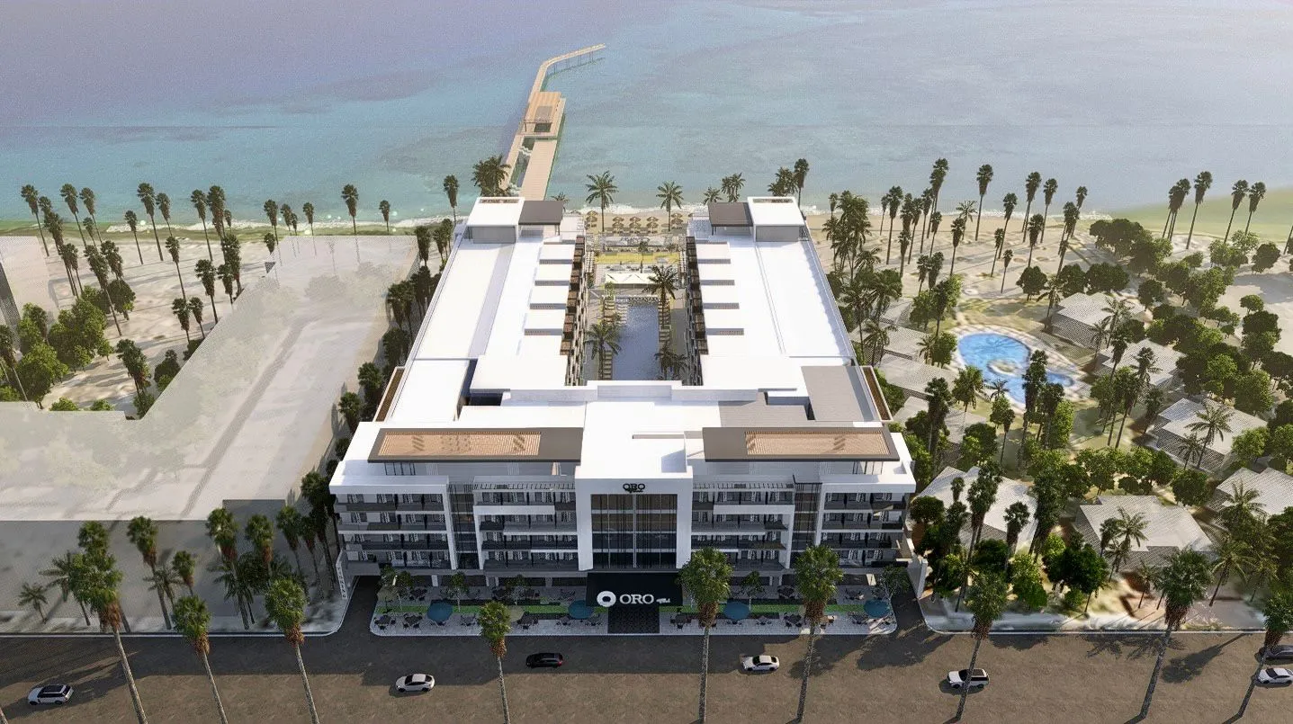 oro — developer visualisation — Aerial view of a modern U-shaped beachfront hotel with a central pool, palm trees, and oceanfront pier.