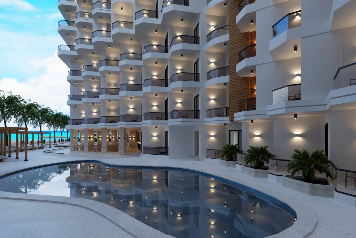storia-del-mare — developer visualisation — Modern resort building with balconies and outdoor lights reflecting in a large pool beside a beachfront with palm trees and lounge chairs.